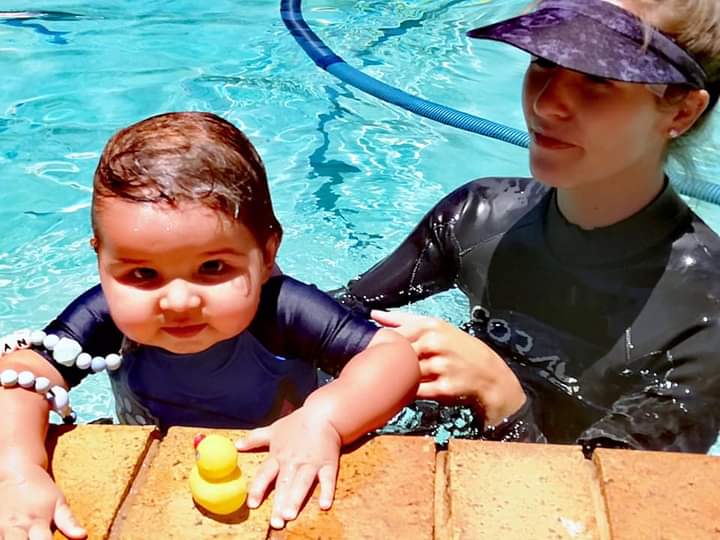 Baby in Pool learning to swim